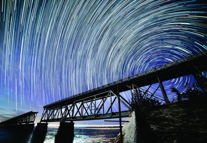 Time Lapse photography showing star circling the bridge at night