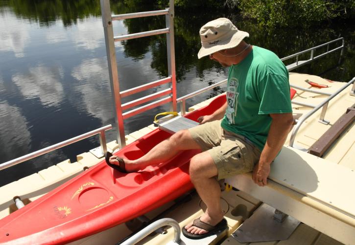 man accessing ADA canoe launch sliding seat