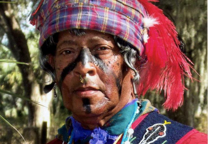 A reenactor dressed in traditional Seminole Native America wear.