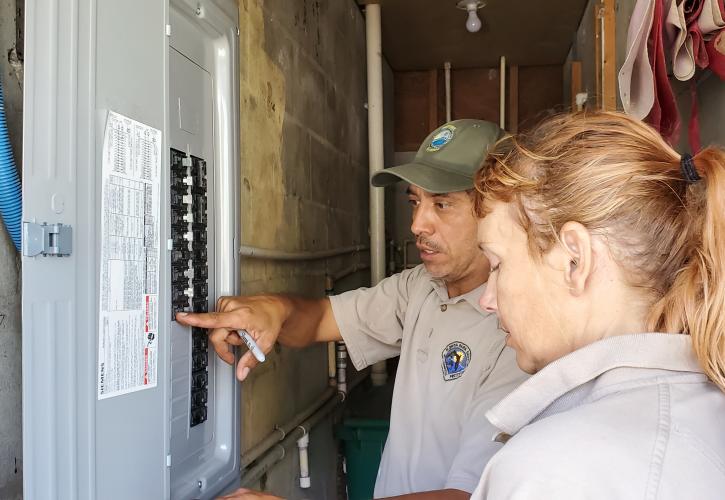 Man and a woman looking at a breaker box