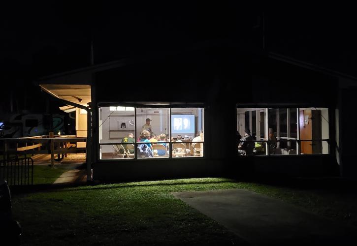 Man speaking to a group of people at night