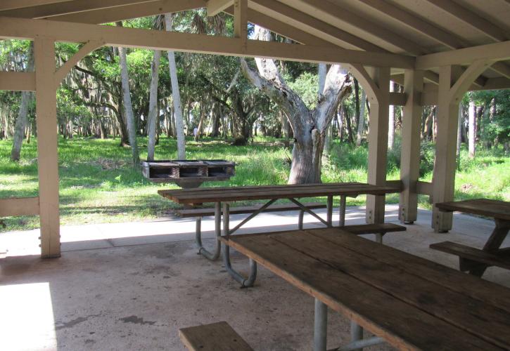 A view from inside the Lake Pavilion shows picnic tables and the grill