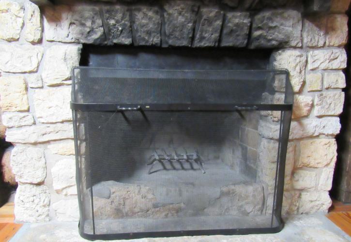 Close-up of the cabin fireplace with grate and shield