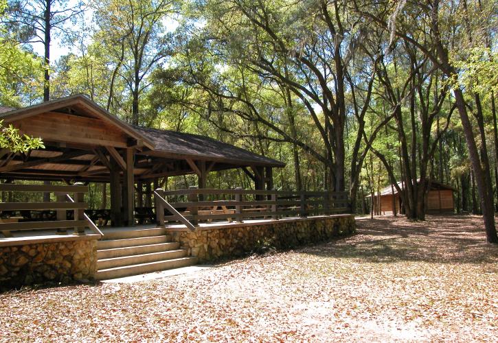 View of the large pavilion shaded by oak trees. 