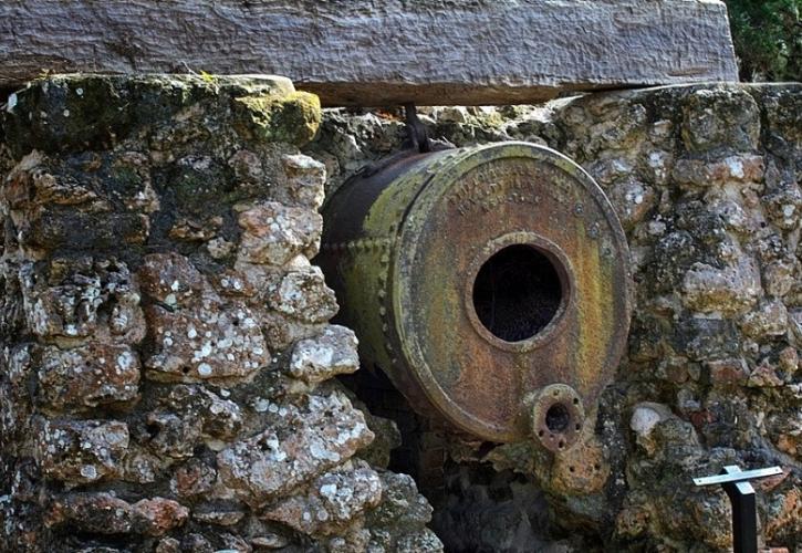 a rusted metal boiler set into a stone wall