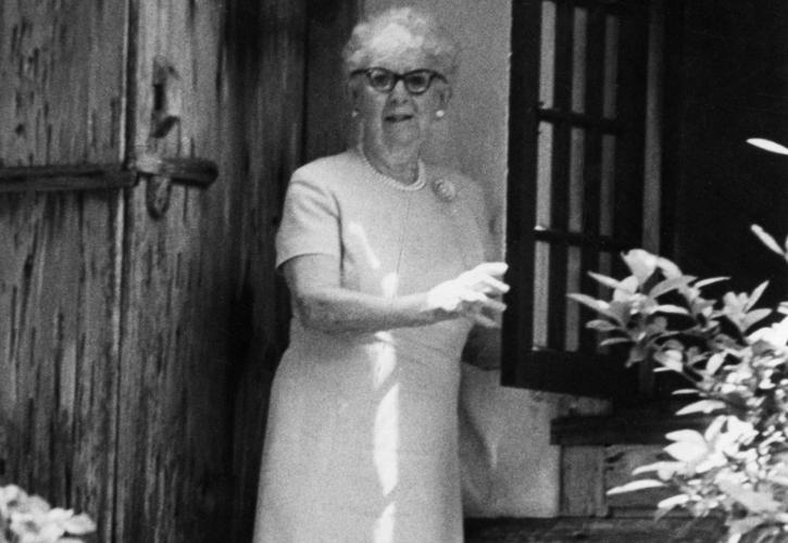 Marjory Stoneman Douglas sits on the steps of her home, with cat. Courtesy of the State Archives of Florida.