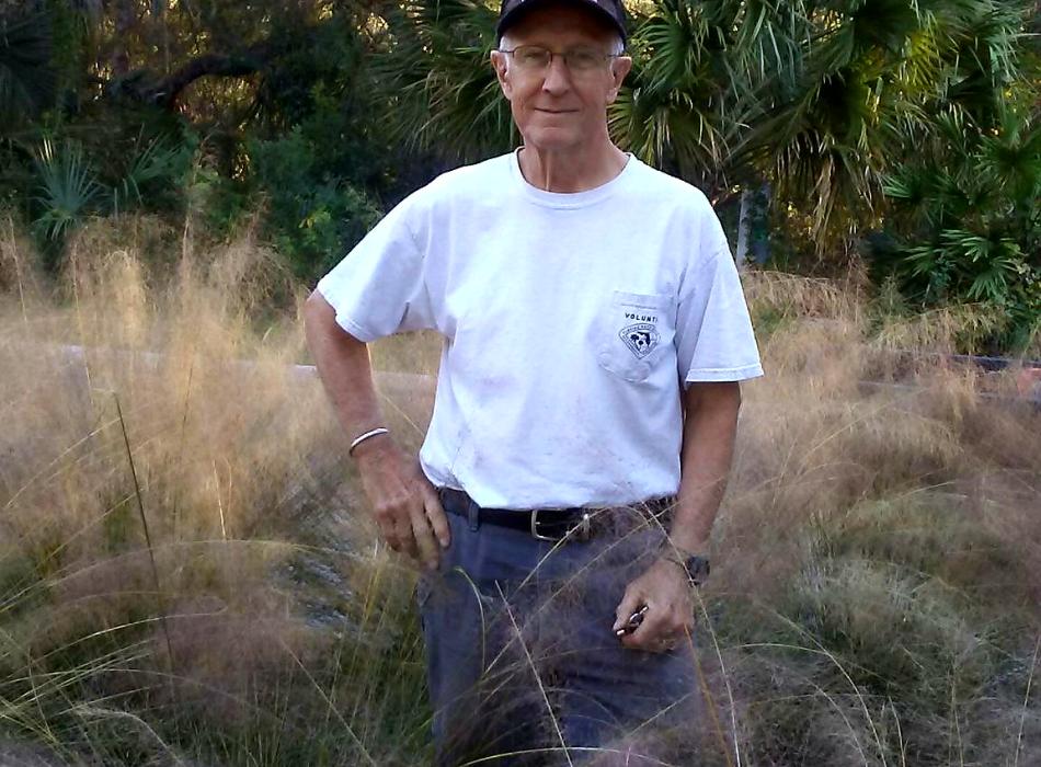 Volunteer Mike Jeakle stands smiling in grass