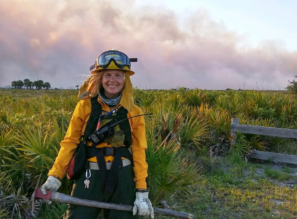 Kissimmee Prairie Staff Spotlight Catie Welch in fire gear holding an axe