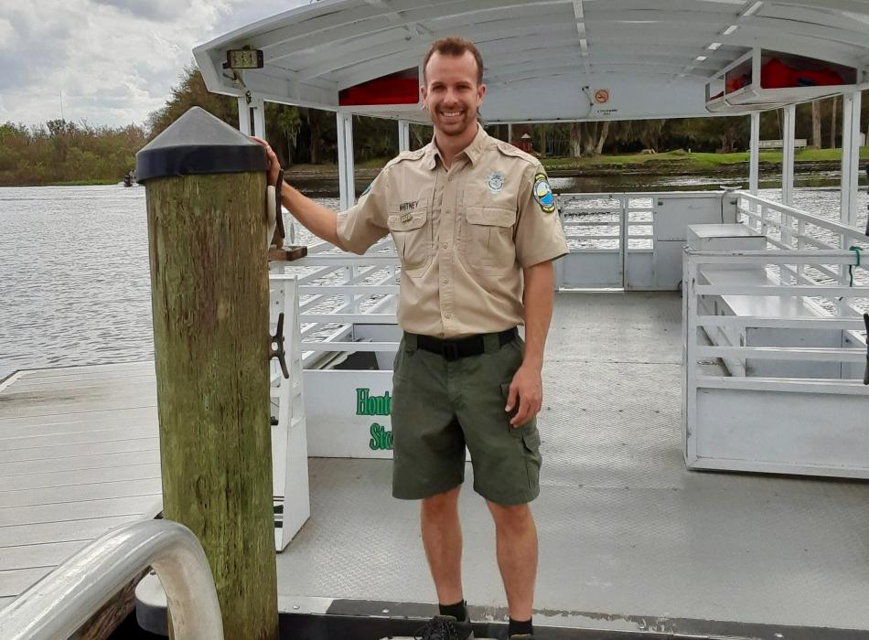 Park Ranger Devin Whitney smiling at the camera in front of the Hontoon Island ferry