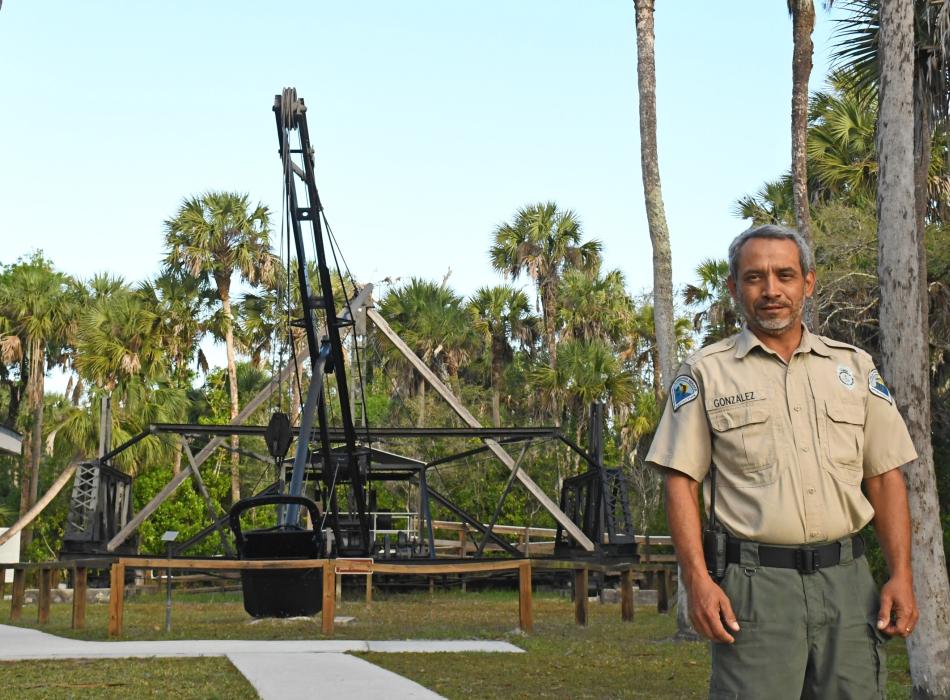 Man standing in front of a dredge machine