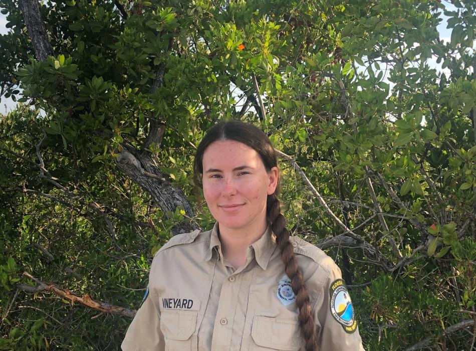Park ranger Krystal Vineyard in front of native vegetation 