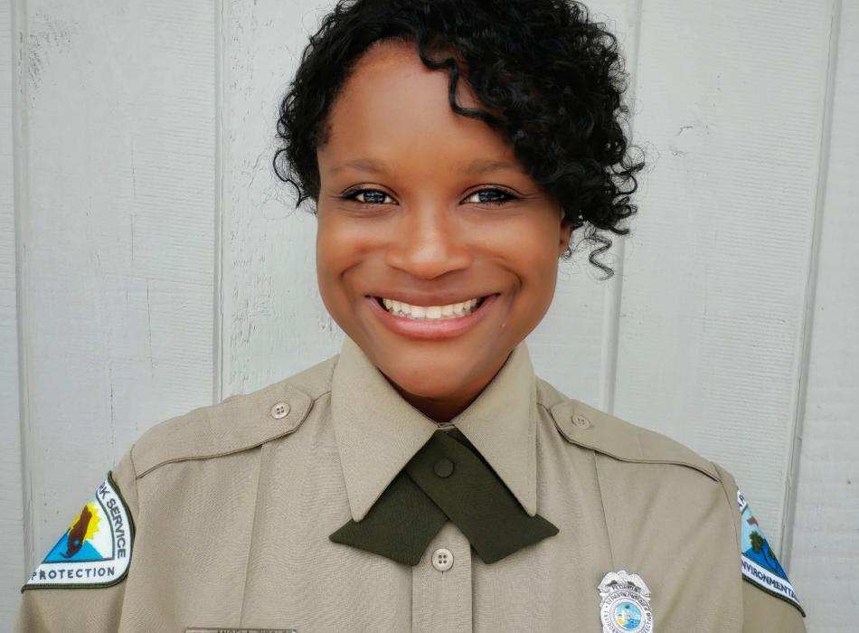 Angela, wearing her ranger uniform, smiling at the camera.