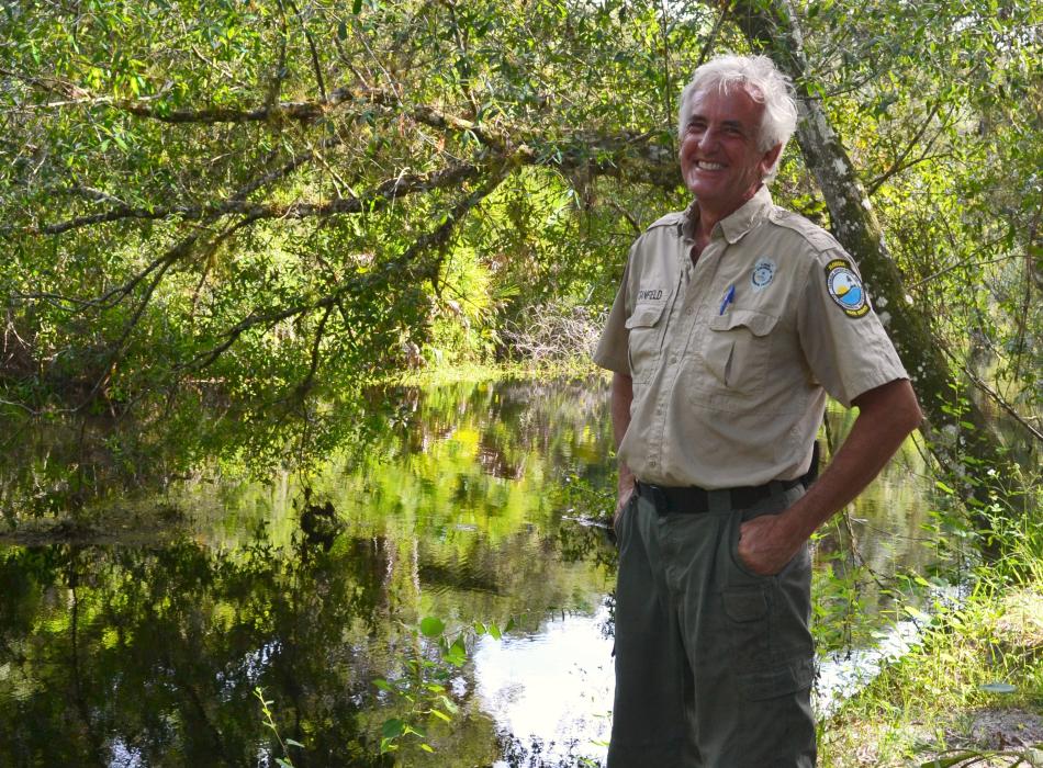 ranger Mike Stanfield standing in front of Clay Gully with willows in background