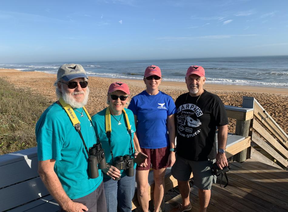 Four North Atlantic Right Whale Survey Members standing on the boardwalk smiling for the picture